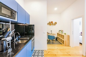 Compact living space with a kitchenette, desk, and comfortable seating area.