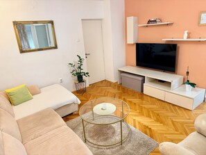 A living room with a sofa, a coffee table, a TV, and a small plant. - Luxury apartment Lolipop - 2 bedrooms, 1 living room, FREE PARKING (Split)