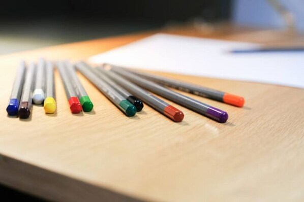 A set of colored pencils arranged on a wooden surface.