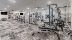 A gym with various exercise equipment, including weight machines and free weights. - Relax at Cityline I Premium 2BR in Dallas (Richardson)