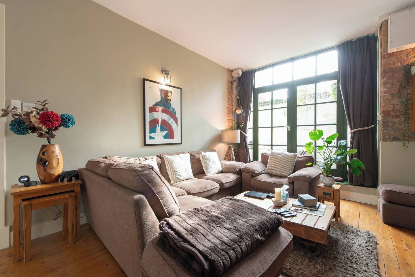 A living room with a sofa, coffee table, and a painting on the wall.