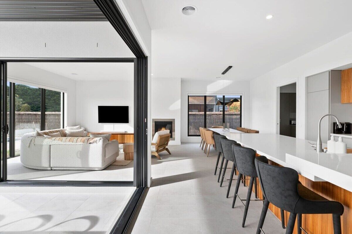 A modern kitchen with a central island, bar seating, and a fireplace.