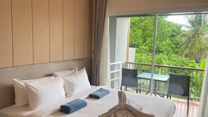 A hotel room with a bed, pillows, a folded towel, a robe, and a balcony with a table and chairs. - Apartment at Palmetto Condo by Lofty (Karon)