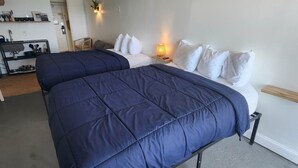 A room with two beds, a small table, a lamp, and a kitchenette area. - Oceanfront Efficiency T609 (Myrtle Beach)