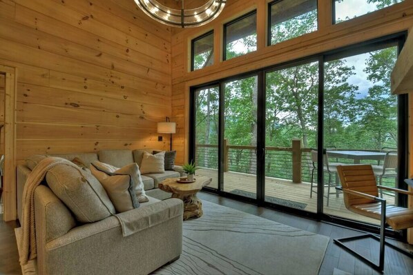 Un intérieur en bois avec un canapé, une petite table et une vue sur l’extérieur.