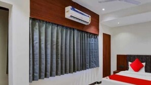 Una habitación de hotel moderna con una cama grande, un ventilador de techo y un equipo de aire acondicionado.