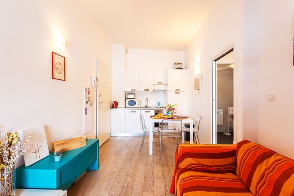 A compact living space with a kitchenette, a dining area, and a sofa. - LA RESERVE AP4369 By Riviera Holiday Homes (Villefranche-sur-Mer)