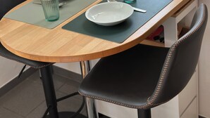 Et spisebord med to tallerkener, to glas og en lampe.