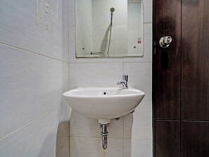 A bathroom with a white sink, a mirror, and a shower.