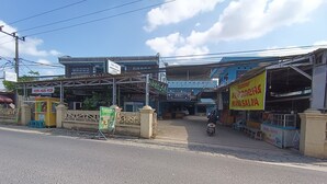 Vista da rua com um carrinho de comida, uma placa de identificação e um edifício com várias placas.