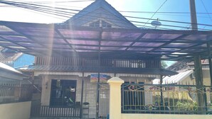 A traditional building with a tiled roof and a covered entrance. - Hotel O Losmen Griya Mulia Katingan Kuala (Pegatan Hilir)