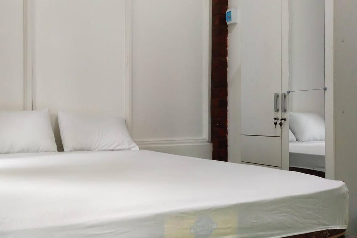 Ein Schlafzimmer mit einem Bett, einem Kleiderschrank und einem Spiegel.