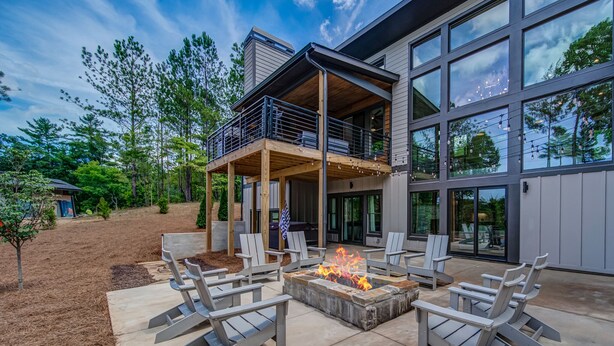 A modern house with a deck, outdoor seating, and a fire pit. - Amazing Grace ~ Indoor Heated Pool ~ Pickleball ~ Basketball ~ Hot Tub ~ Fire Pit (Ellijay)