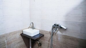 A bathroom with a white sink, a shower, and a towel rack. - Roomshala 035 Premium Inn Noida Sec 15 (Noida)