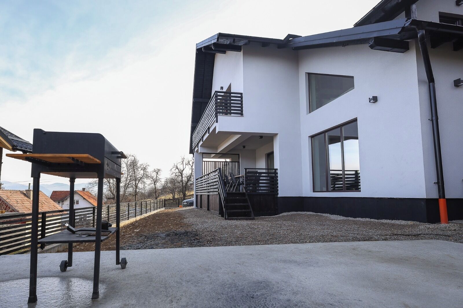 A modern building with a balcony, a staircase, and a view of the surrounding area.