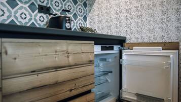 Una cocina con un armario de madera, horno empotrado y refrigerador con compartimento 'Fresh Zone'.