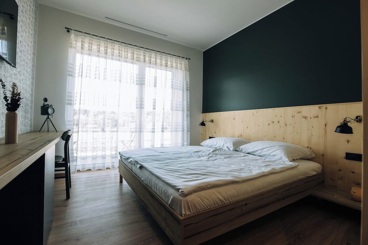 A bedroom with a wooden bed, a desk, and a chair.