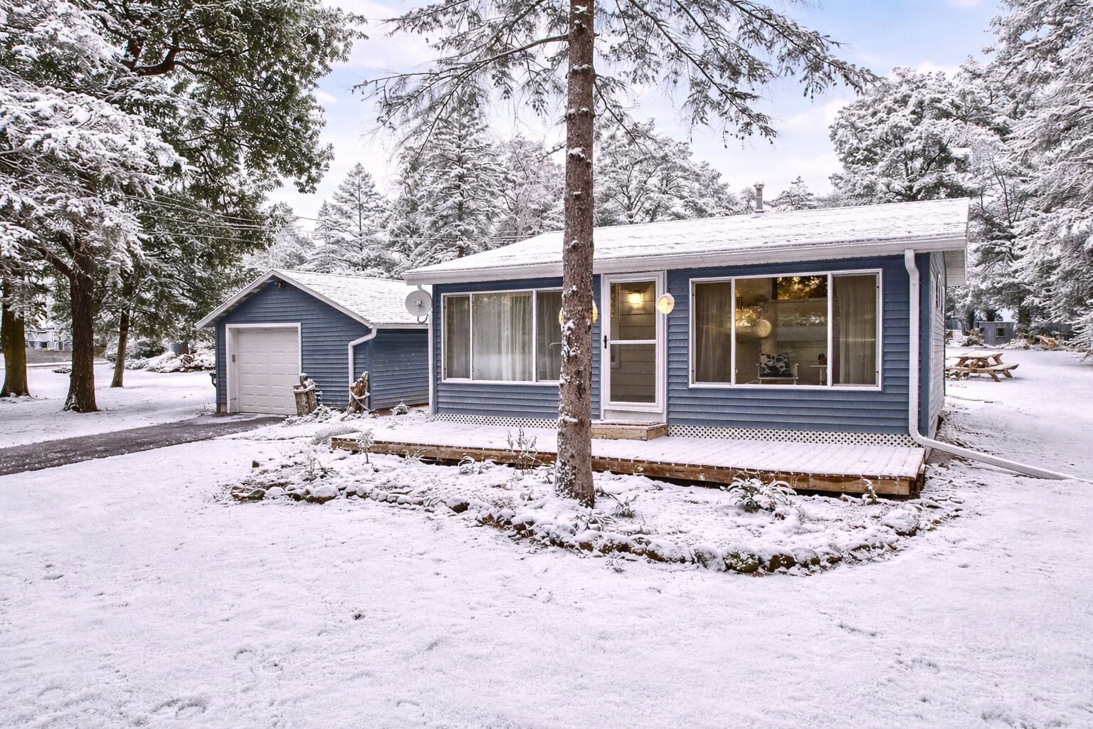 Cozy cabin with private yard and snowy forest views, perfect for a peaceful winter getaway.