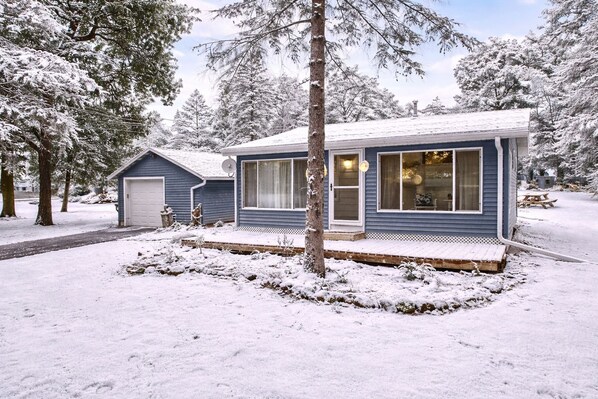 Cozy cabin with private yard and snowy forest views, perfect for a peaceful winter getaway.