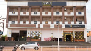 A multi-story building with a sign for 'TWJ Hospitality'. - Hotel Nakshtra, Shrungartali (Guhagar)