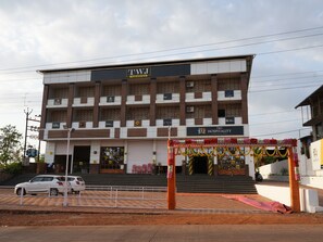 Un edificio de varios pisos con un cartel que dice "TWJ Hospitality".
