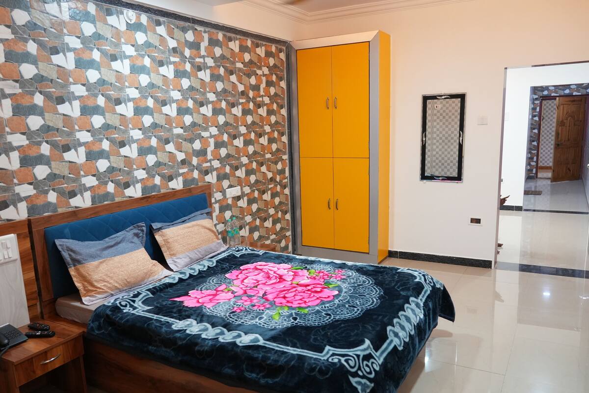 A bedroom with a bed, a wardrobe, and a tiled wall.