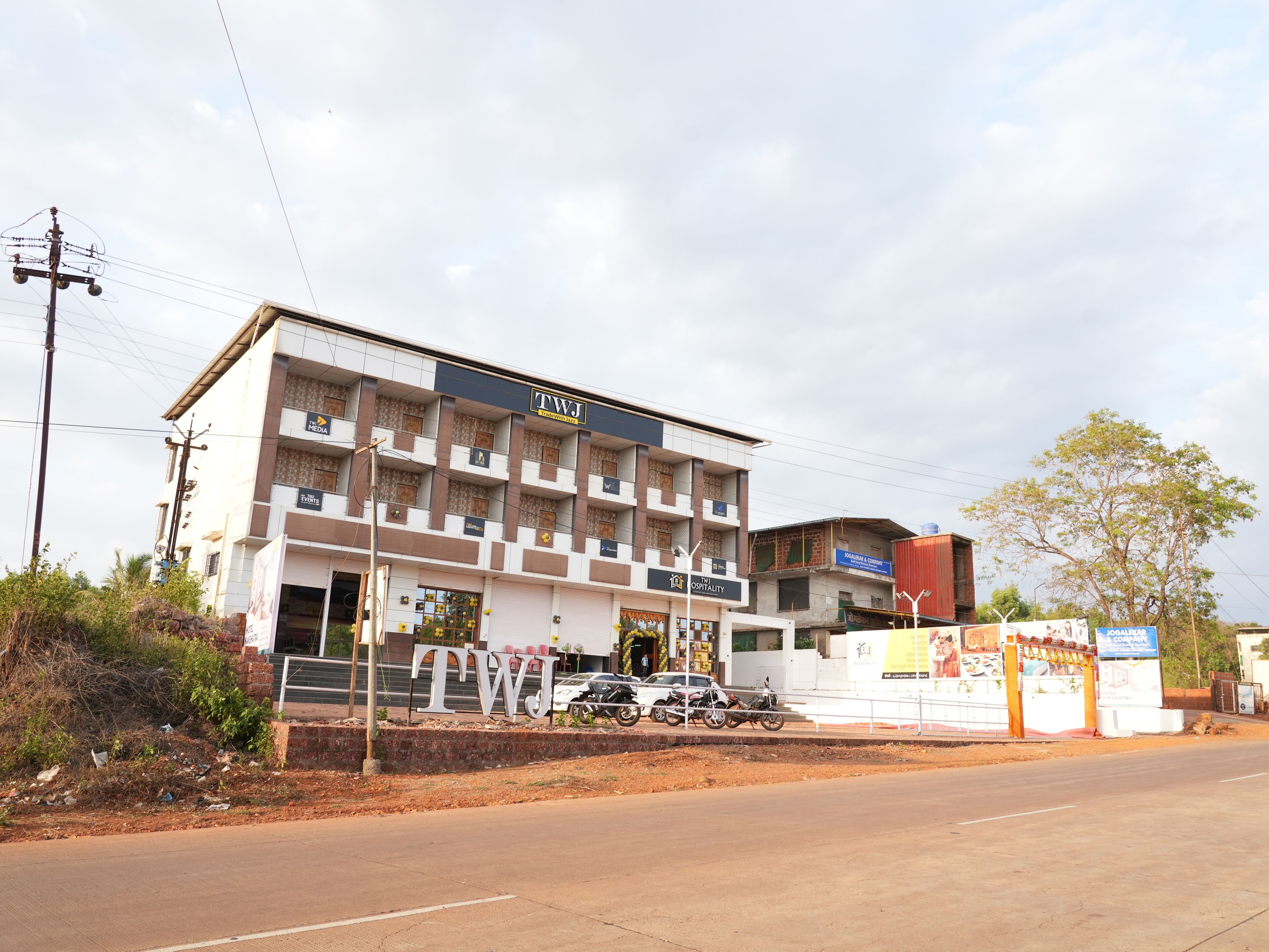 A multi-story building with a sign reading "TWJ Hospitality."