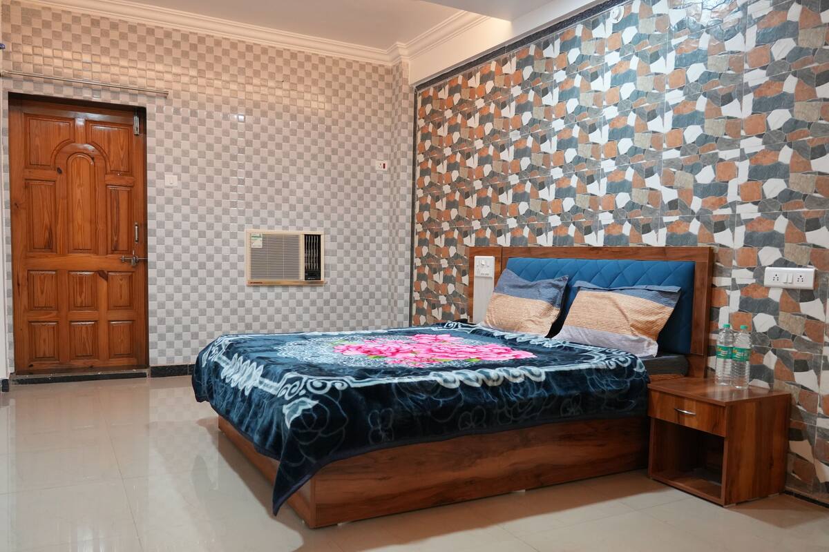 A bedroom with a wooden bed, a checkered wall, and a mosaic wall.