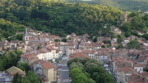 A town with historic buildings, a church, and a road leading through it.