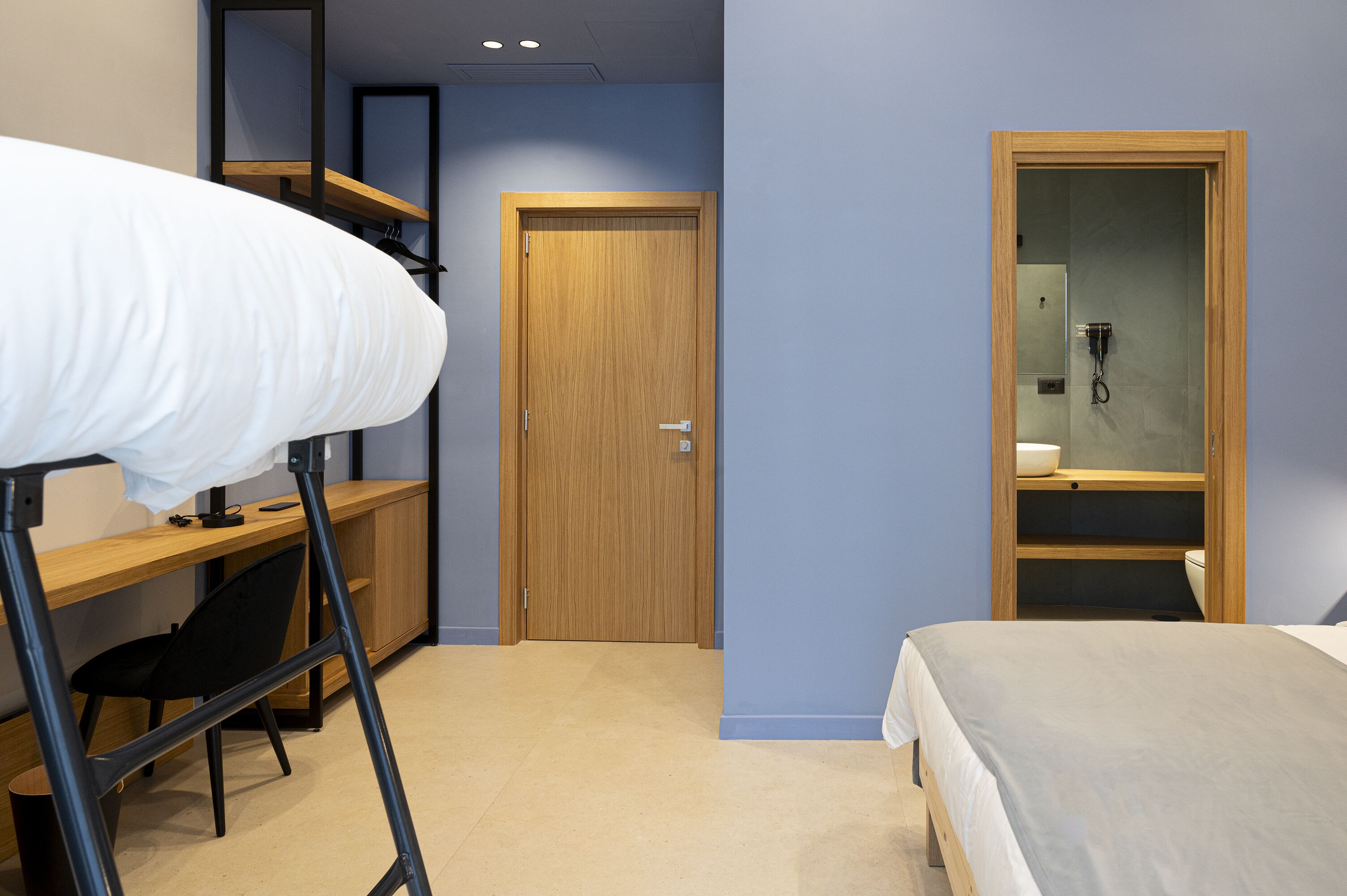 Una camera da letto con un letto a castello, una scrivania, una sedia e una porta in legno.