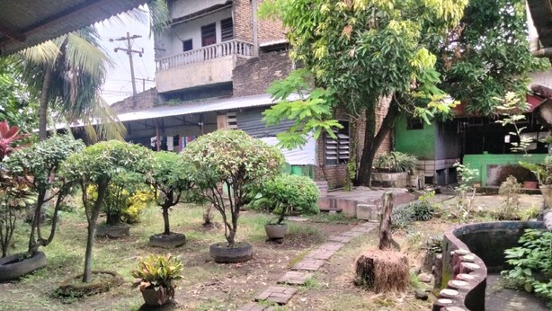 A garden with various potted plants and a brick pathway. - Hotel O Penginapan Keluarga (Medan)