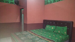 A room with a bed, a door, and a wall with a geometric pattern. - Hotel O Penginapan Keluarga (Medan)