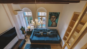 A cozy living room with a blue sofa, a TV, and a painting on the wall.