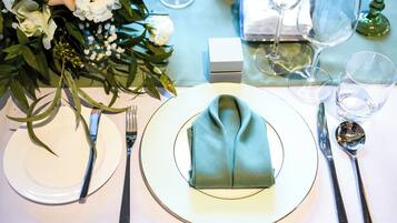 A table set with white plates, silver cutlery, and a folded napkin.