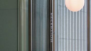 Un mostrador de recepción con encimera de mármol y un cartel que indica 'RECEPTION' y 'BEIJING'.