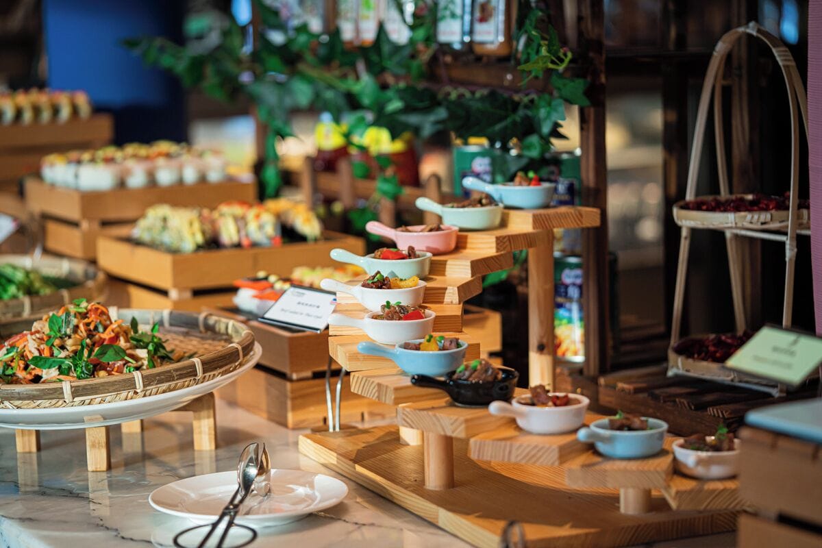 A buffet setup with various dishes and a menu sign.