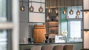 Une cuisine moderne avec des suspensions sphériques, un tonneau en bois et des tabourets de bar.