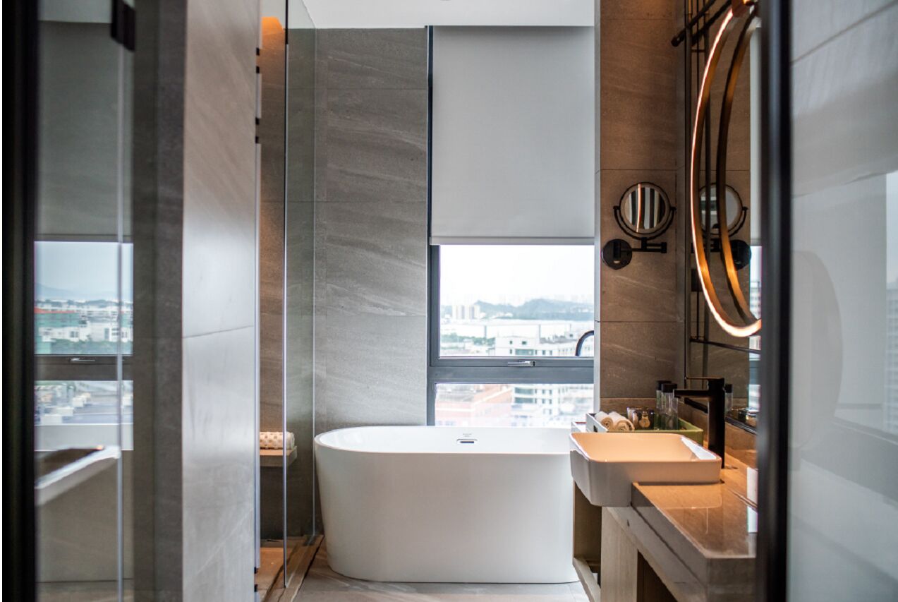 Une salle de bain moderne avec une baignoire sur pieds, une grande fenêtre et un design minimaliste.