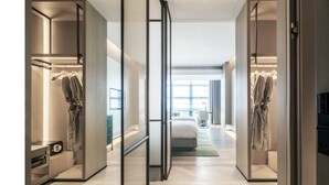 Une chambre d’hôtel moderne, dotée d’un grand lit, d’un bureau et d’une armoire.
