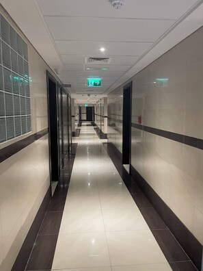 Experience the sleek, contemporary design of our hotel's corridors, featuring glossy tiled floors and elegant glass doors.