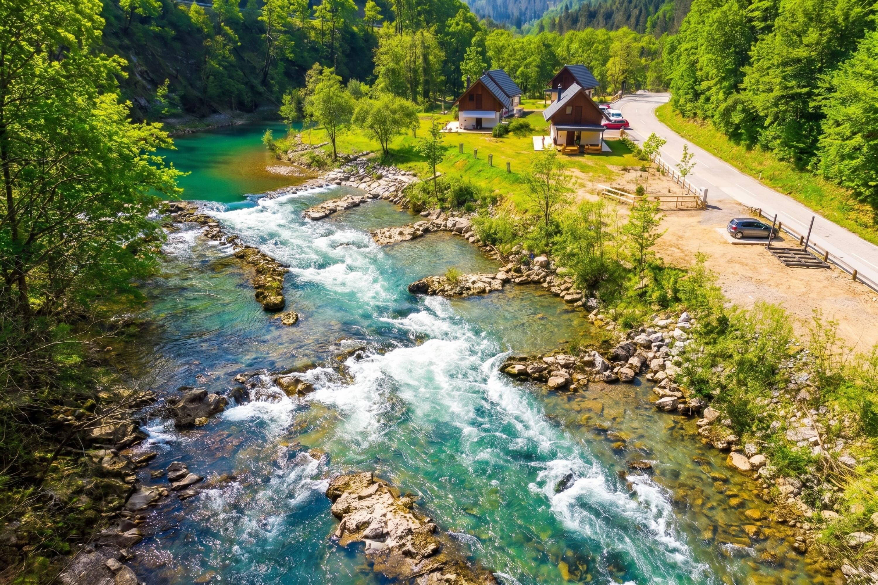 A river flowing through a valley with houses on the right.
