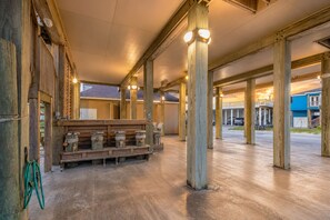 A spacious indoor area with wooden beams and columns, benches, and a view of the outside.