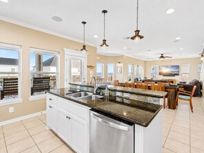 A modern kitchen with a central island, stainless steel appliances, and pendant lighting. - Steps to Beach | 4BR | Deck + Ocean Views (Crystal Beach)