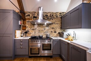 Modern kitchen with stainless steel appliances, double oven, and range, perfect for cooking and baking.