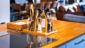 A modern kitchen with a wooden countertop, a knife block, and two pendant lights. - The Cow Shed @ Atlow Mill (Atlow)