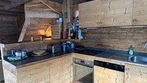 A wooden kitchen with a built-in oven, a dishwasher, and a sink.