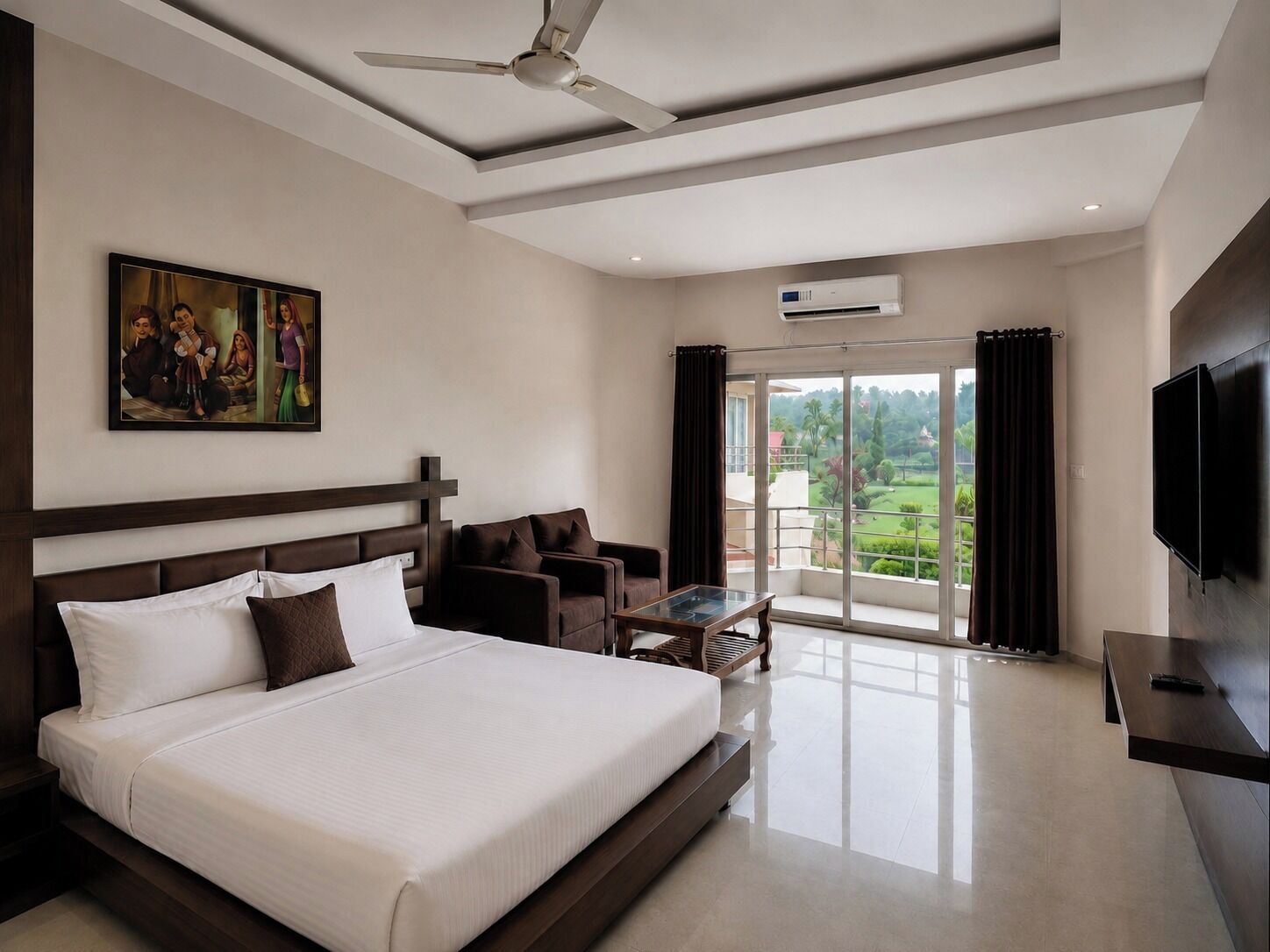 A hotel room with a large bed, a ceiling fan, a TV, a painting, and a balcony with a view.