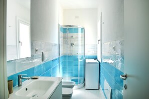 A bathroom with a shower, sink, and toilet.