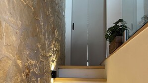 Una escala de fusta amb un mur de pedra a un costat.