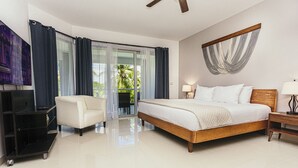 A hotel room with a bed, a chair, a TV, and a balcony with curtains. - Cozy & NEW unit Steps from the Beach sleeps 6 Casa Magallon (Playa del Carmen)